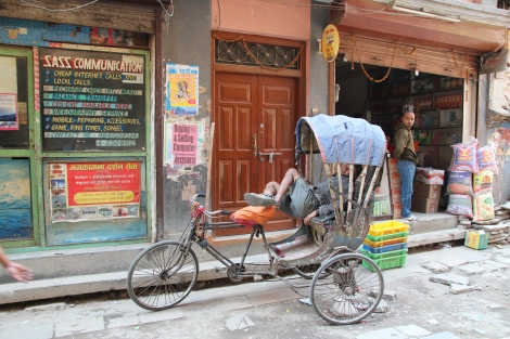 A napping rickshaw driver